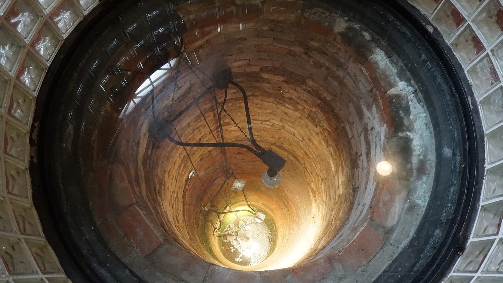 Looking down the round, brick-lined artesian well at the Dr Pepper Museum, lit from below